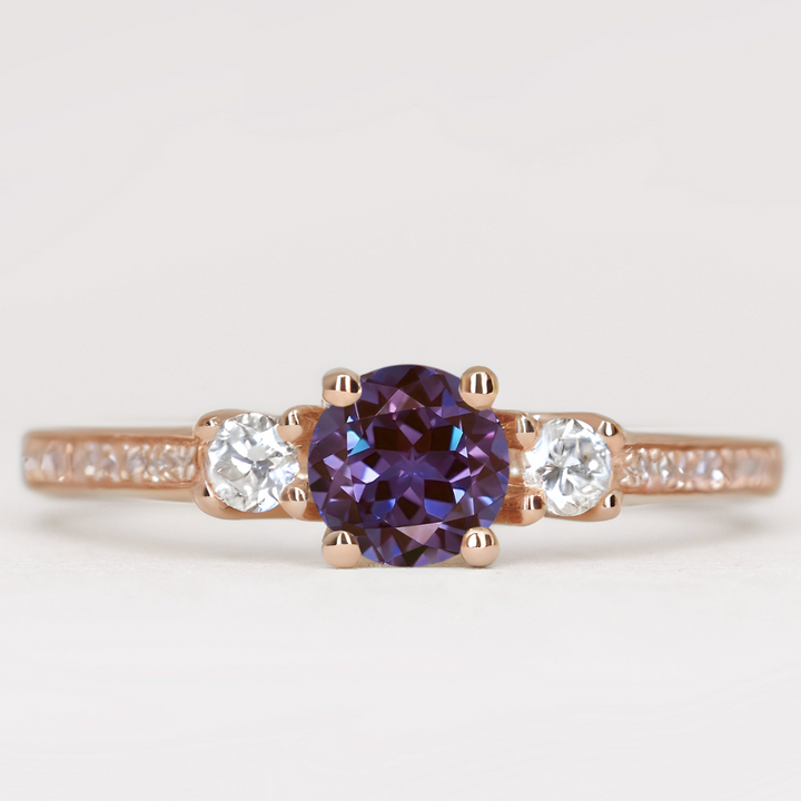 Round cut alexandrite and diamond trilogy engagement ring with white diamond pave band