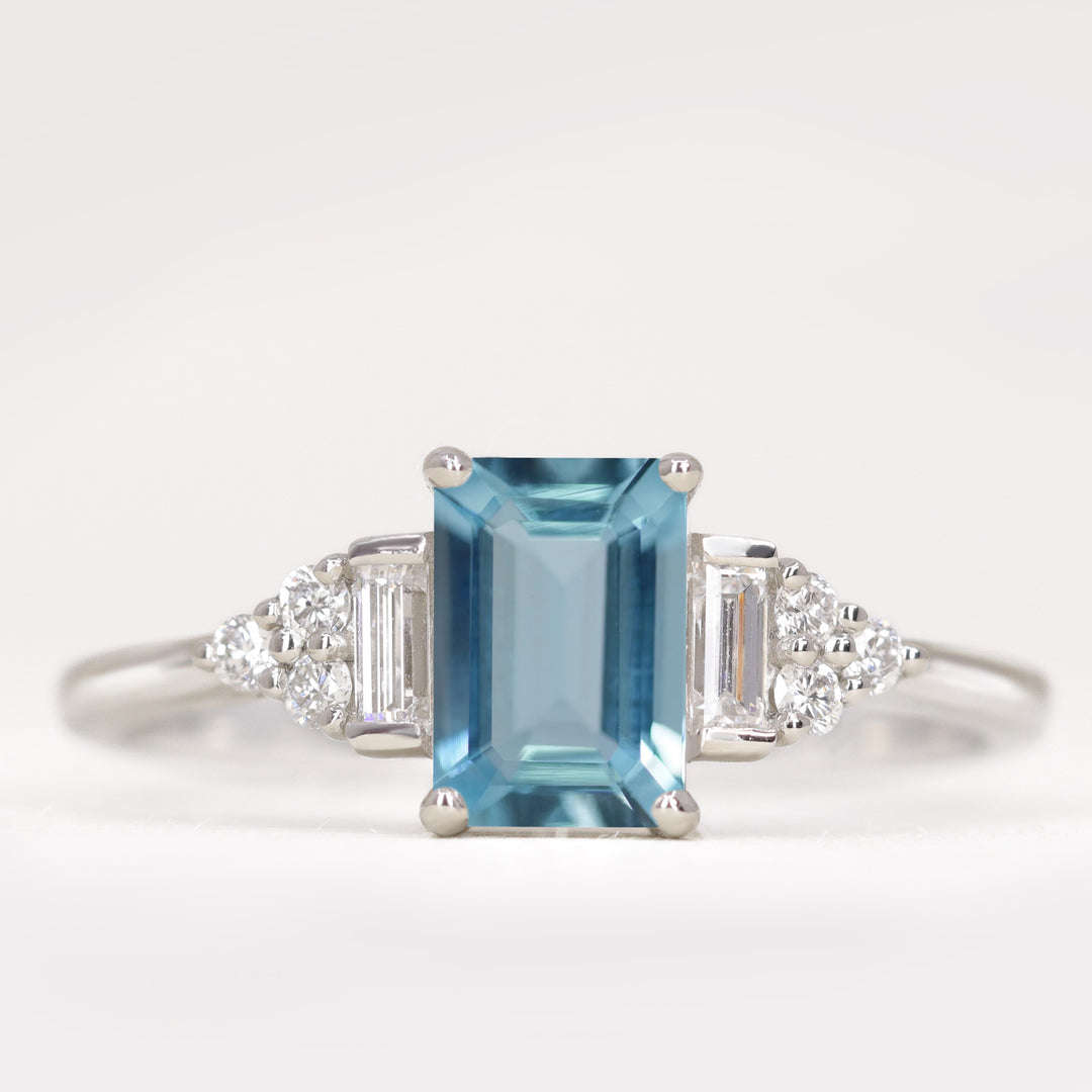 Art deco emerald cut aquamarine engagement ring with white diamond side stones