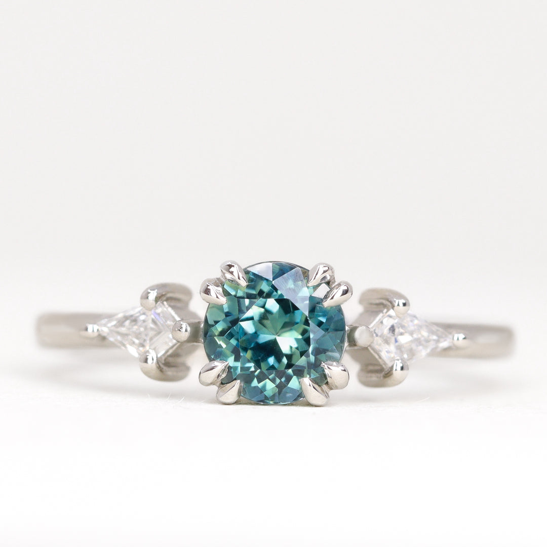 Round teal sapphire with white diamonds engagement ring in platinum