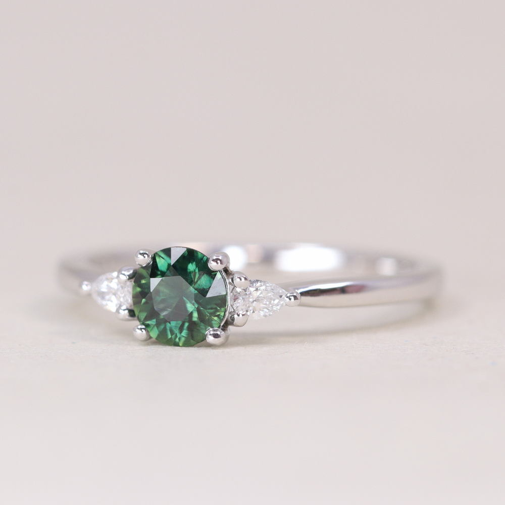 Elspeth - Round Cut Green Teal Sapphire Trilogy Engagement Ring - Ready-to-Wear Engagement Rings - Ready-to-Ship