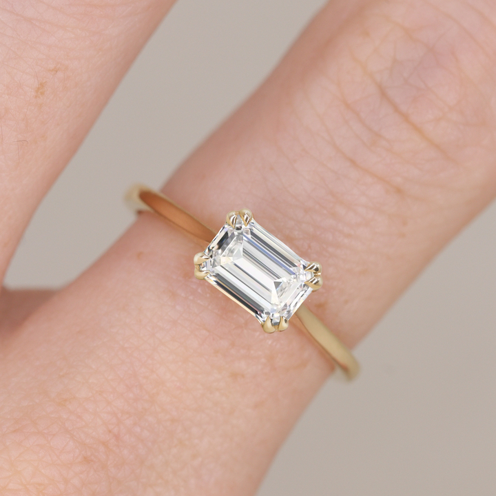 Emerald cut east west set diamond solitaire engagement ring