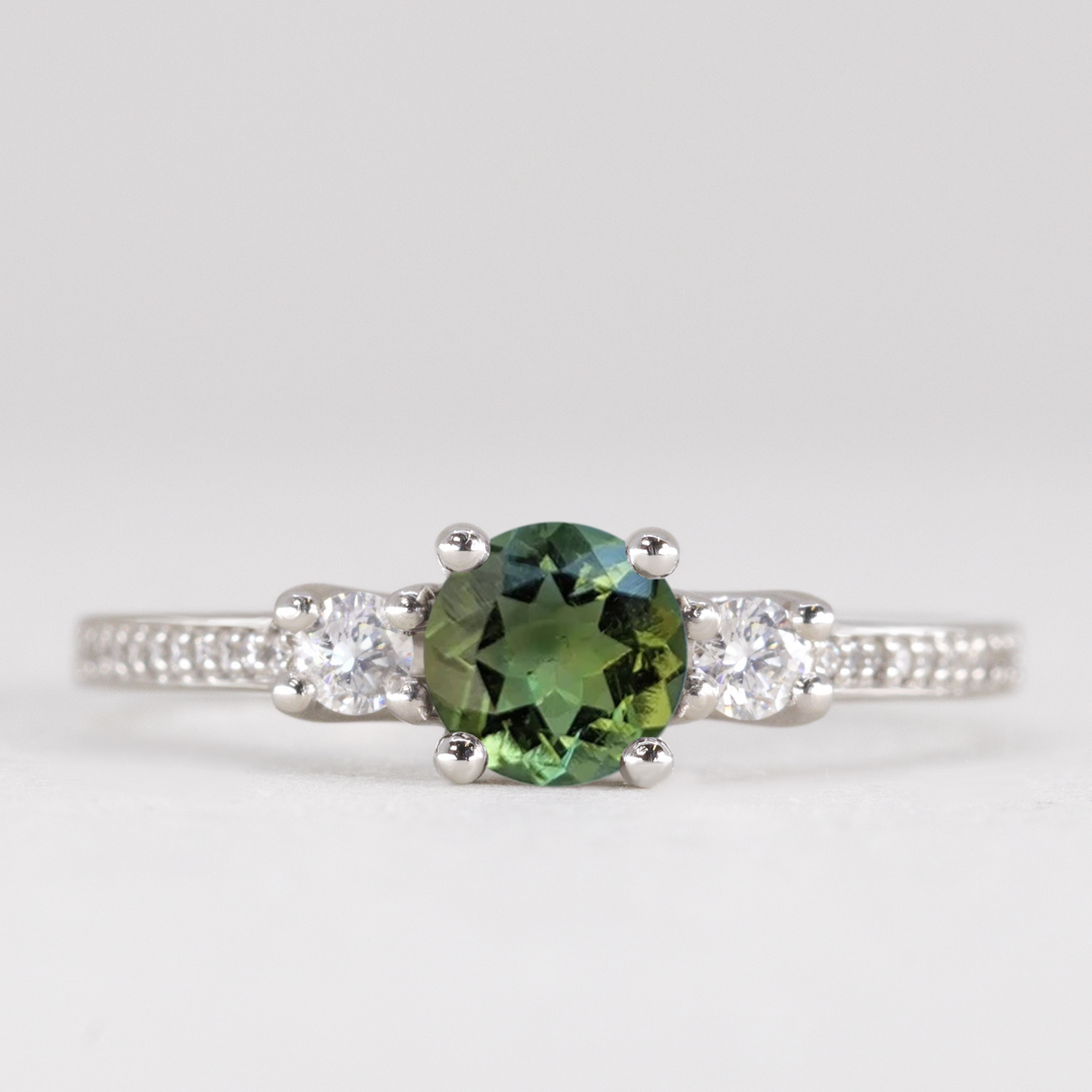 Round cut tourmaline and diamond trilogy engagement ring with white diamond pave band