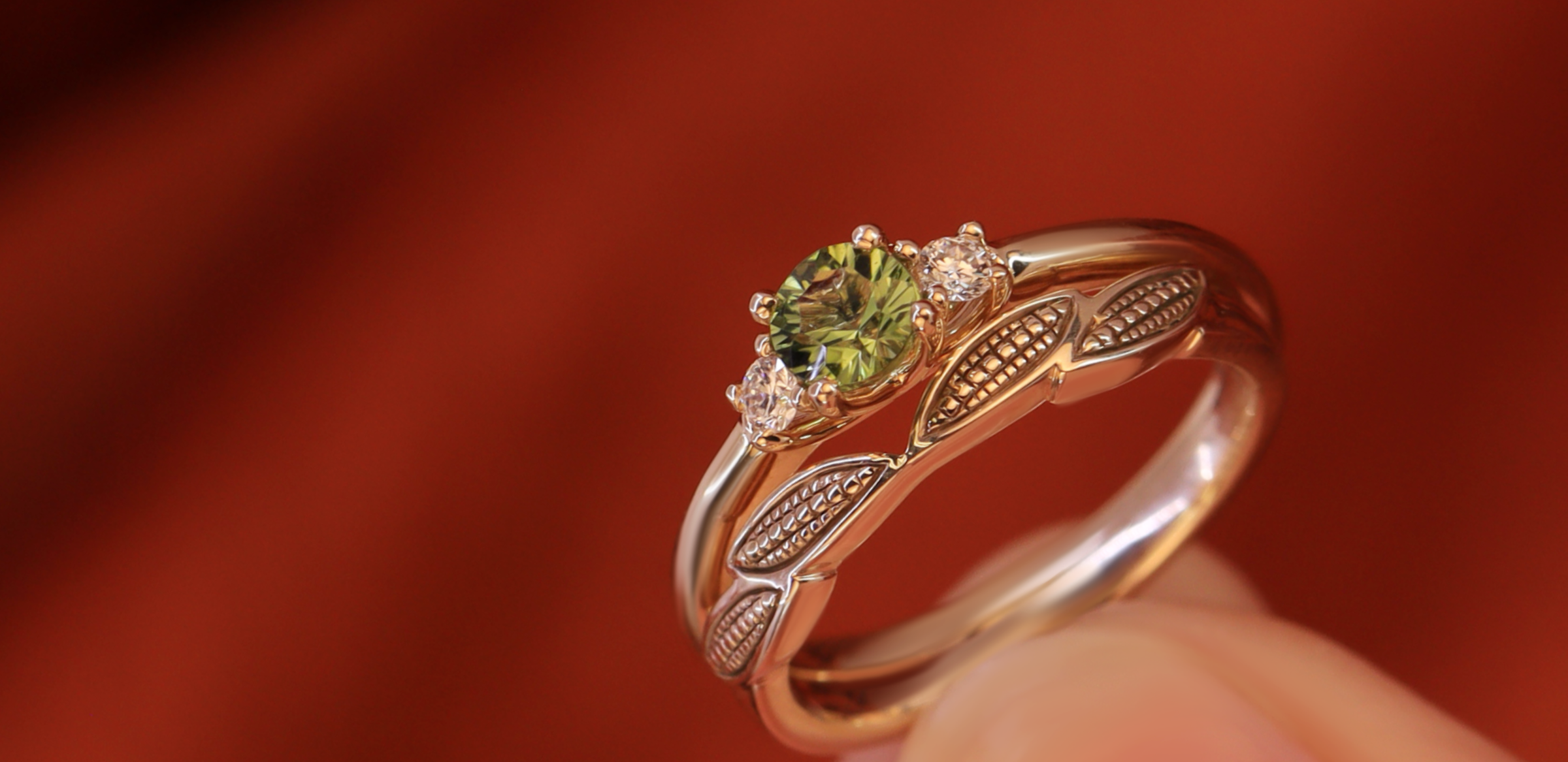 Gold ring with a green gemstone on a brown background