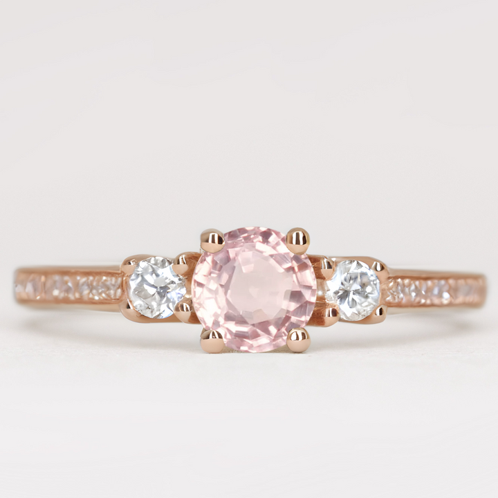 Round cut morganite and diamond trilogy engagement ring with white diamond pave band