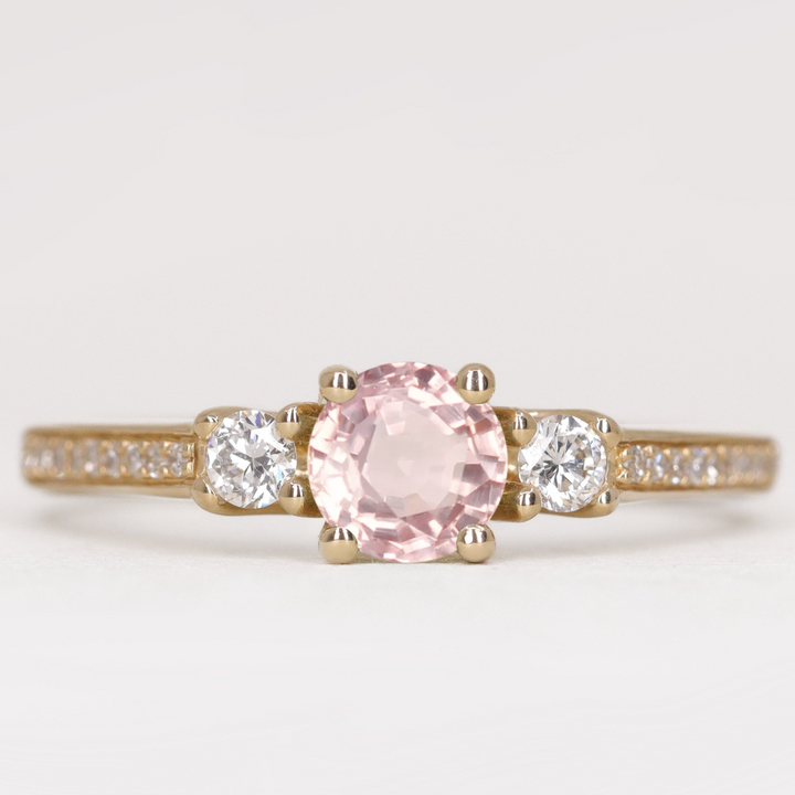 Round cut morganite and diamond trilogy engagement ring with white diamond pave band